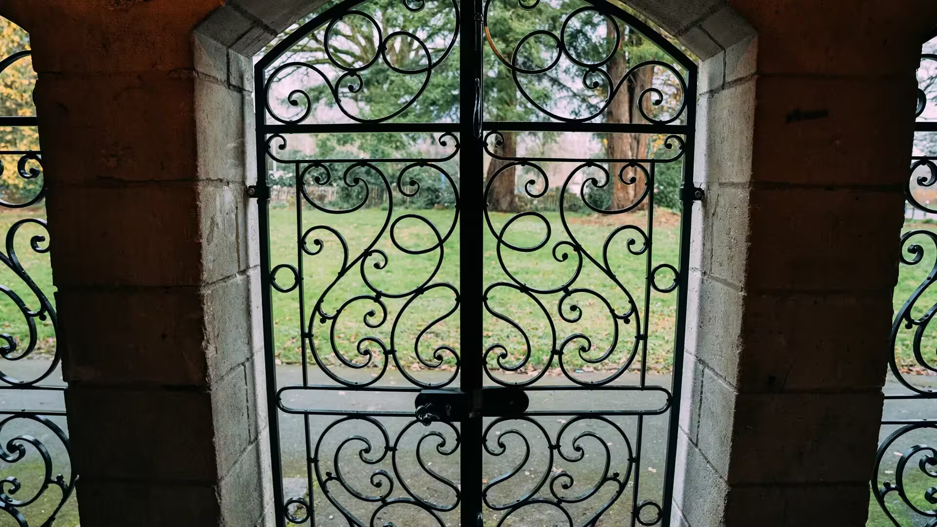 Grille centrale en fer forgé vue depuis l'intérieur, ouvrant sur un parc, ferronnerie traditionnelle Coyac près de la Beaujoire à Nantes