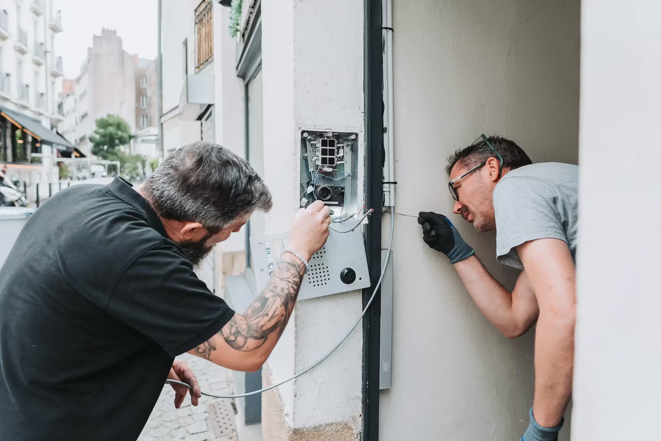 Techniciens Coyac réparant un interphone sur la façade d'un immeuble à Nantes