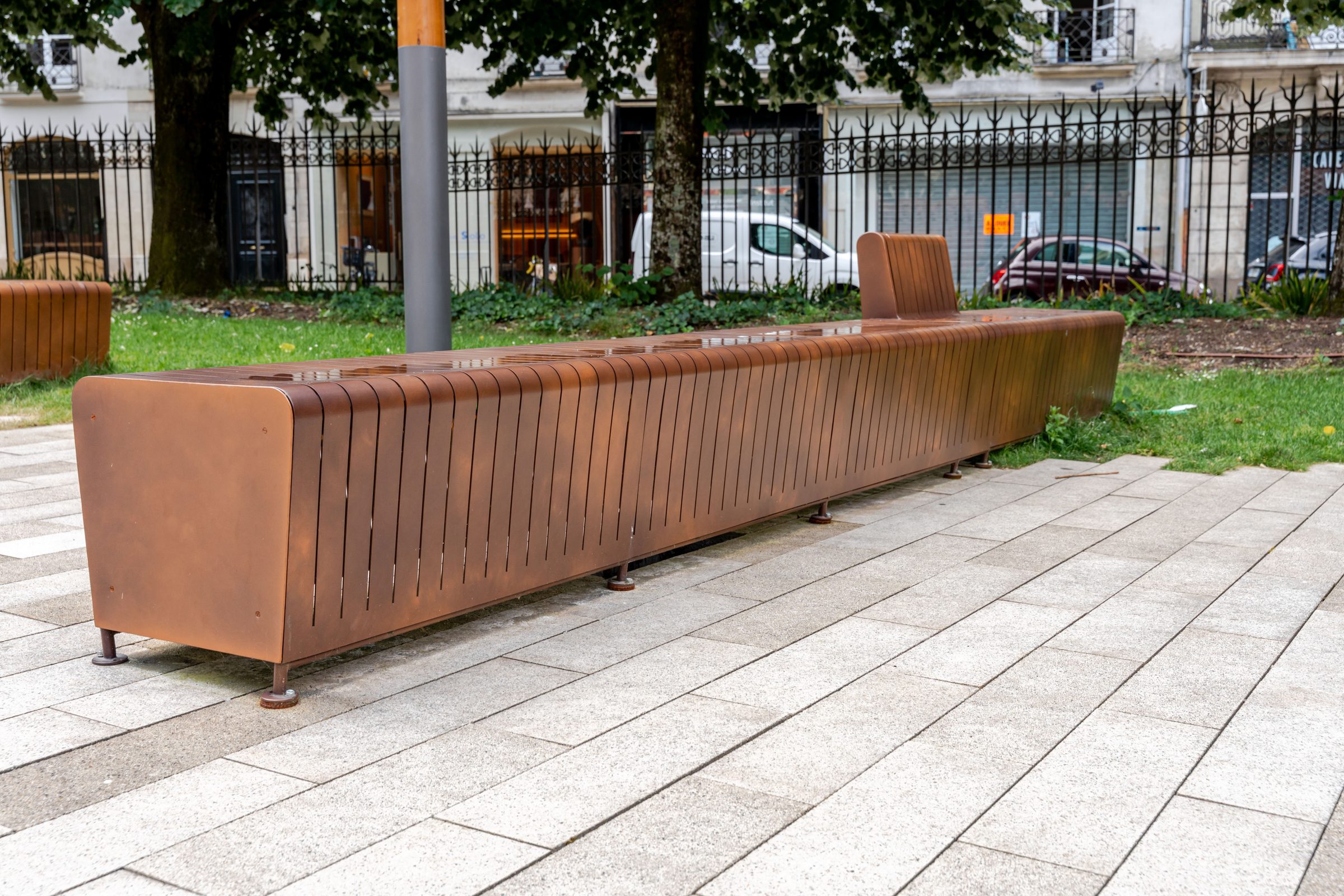 Long banc métallique extérieur en tôle pliée avec dossier, place Jean V à Nantes